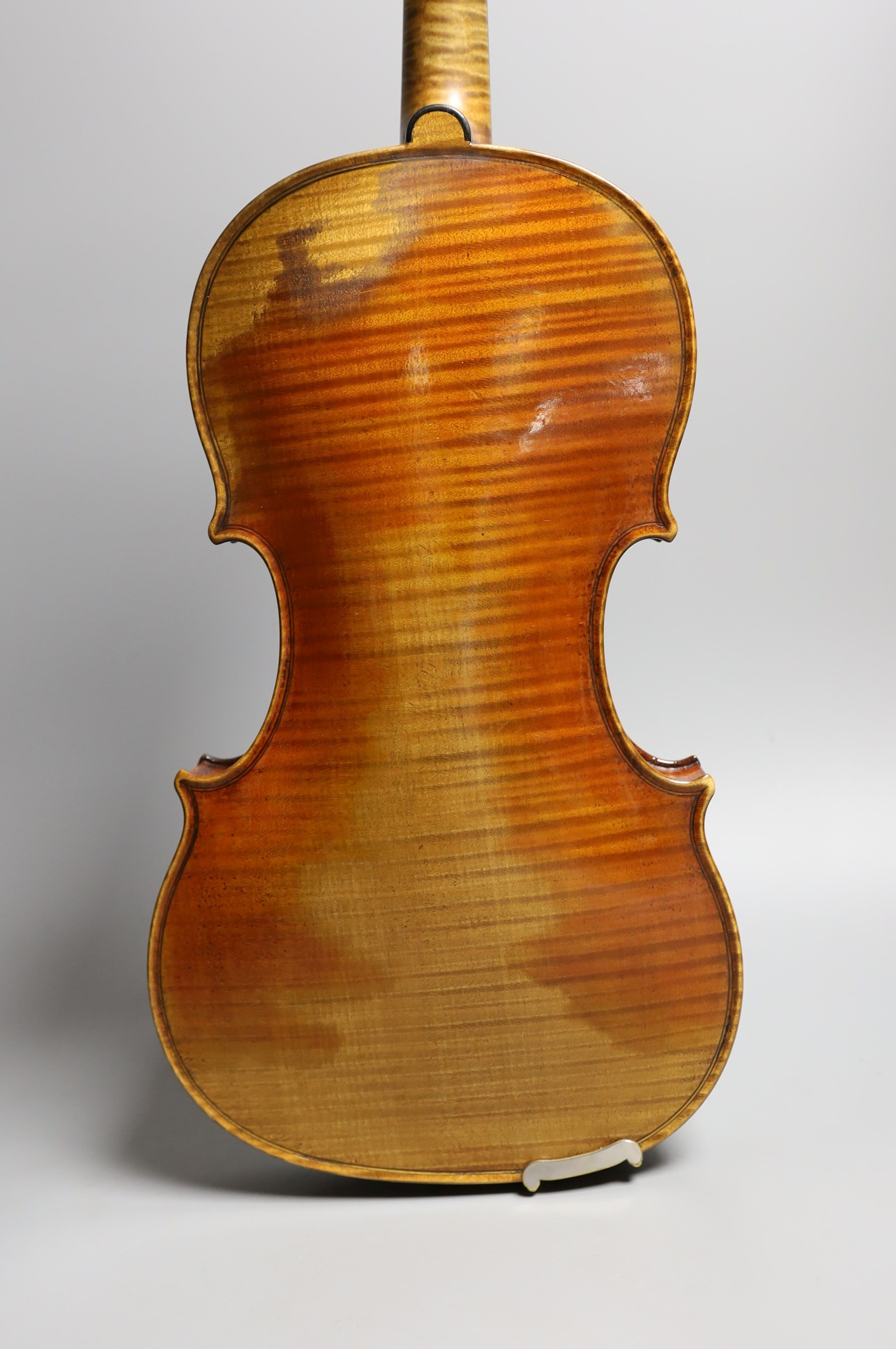 A 19th century violin labelled JB Guadagnini, back measures 35cm, with two bows, one silver-mounted.